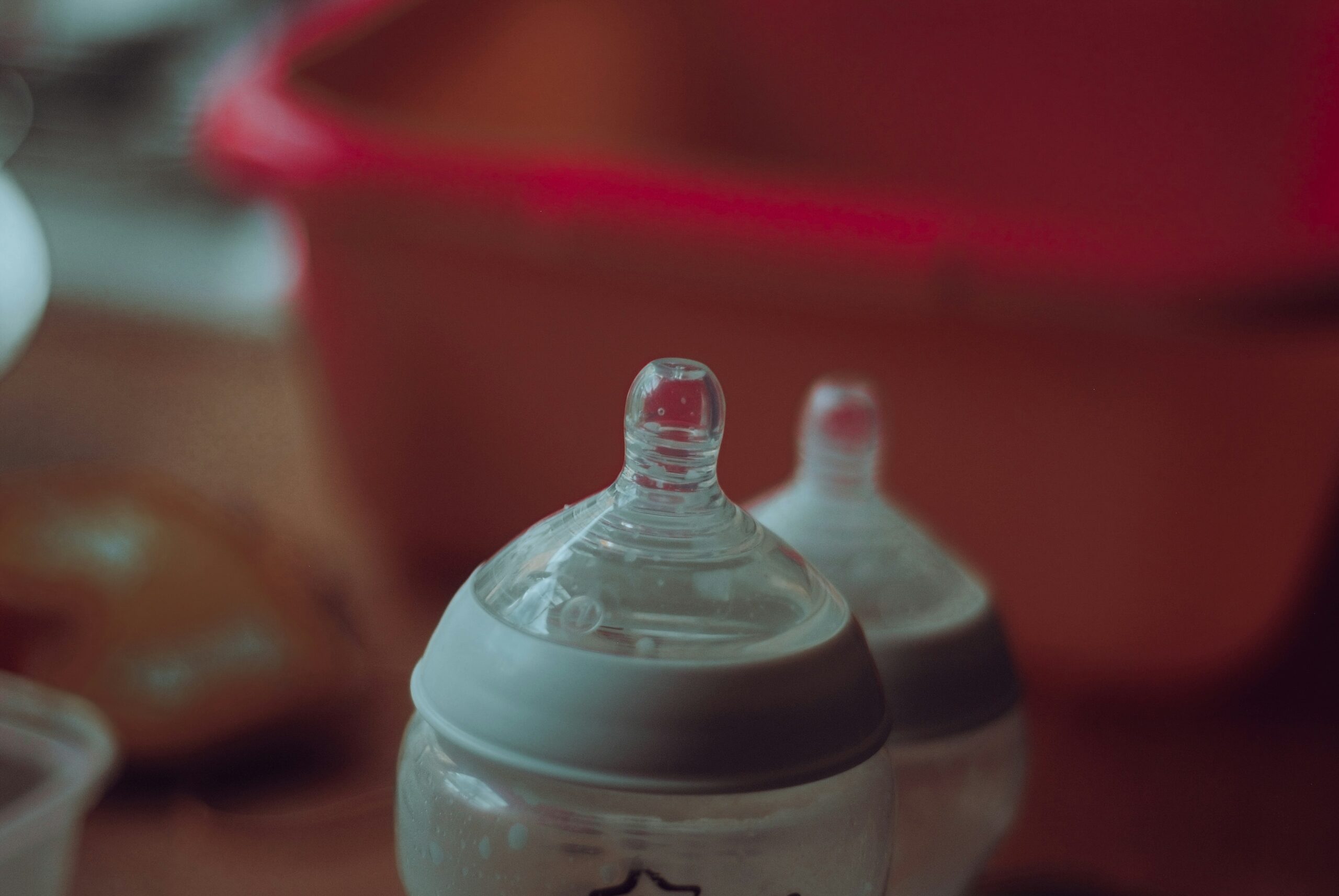 Two baby bottles prepared for paced bottle feeding, showcasing the clear nipples and components against a soft background.