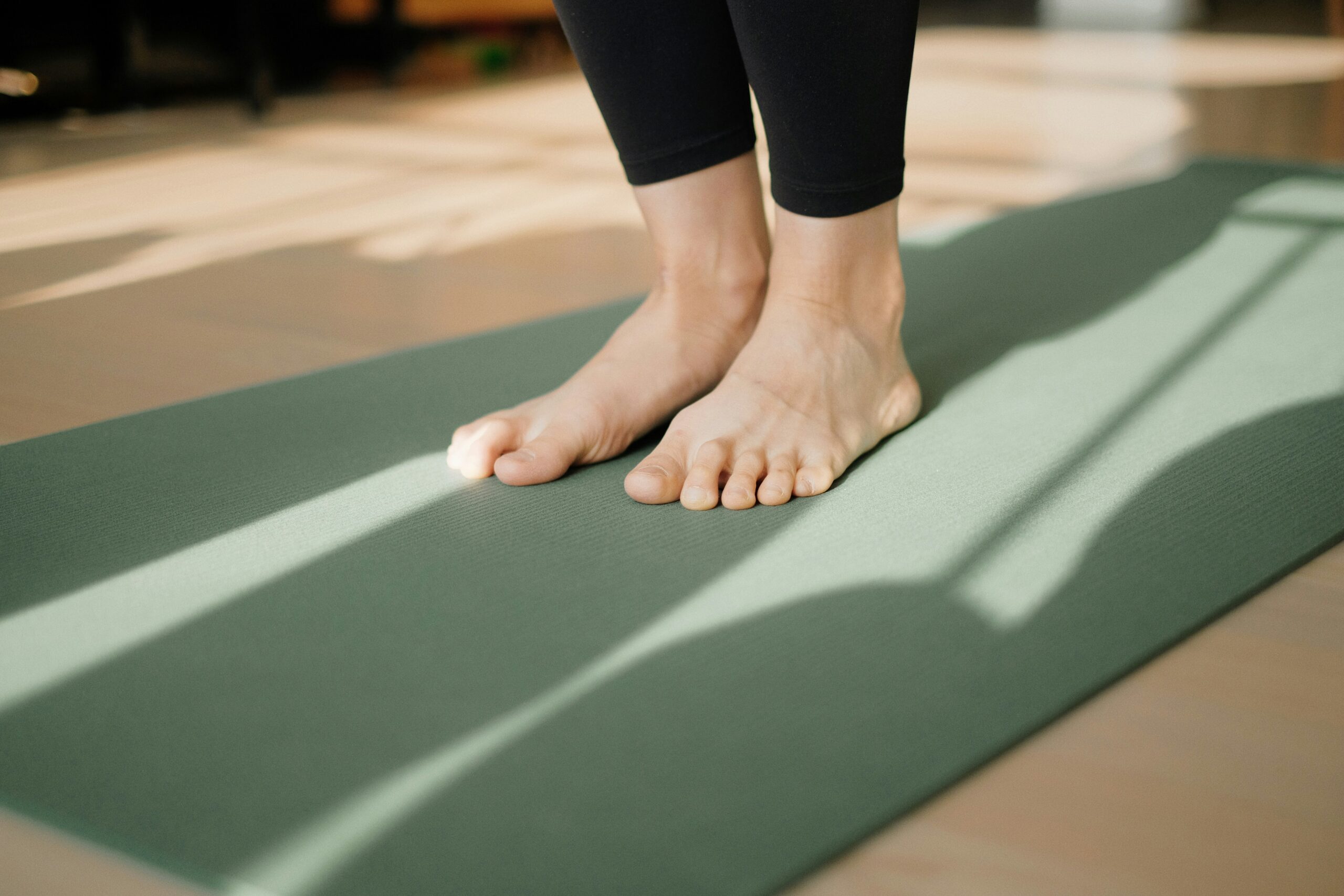 A person's bare feet on a yoga mat, ready to begin their pelvic floor exercises in a serene setting.