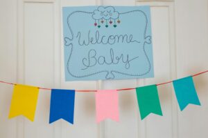 A welcoming "Welcome Baby" sign with hearts, celebrating newborn home visits in a cheerful nursery.